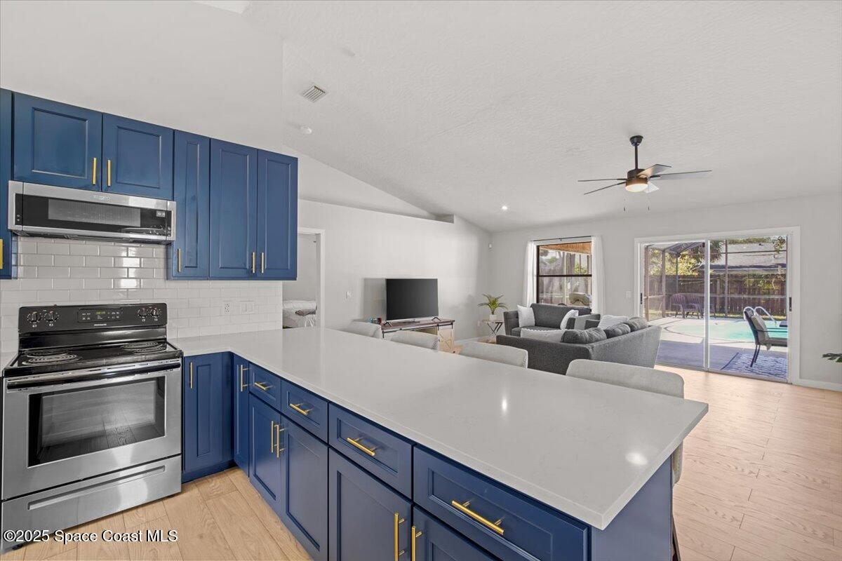 1709 Palm Ridge Road Melbourne, FL 32935 - Photo 12 of 43 a kitchen with sink a stove and cabinets