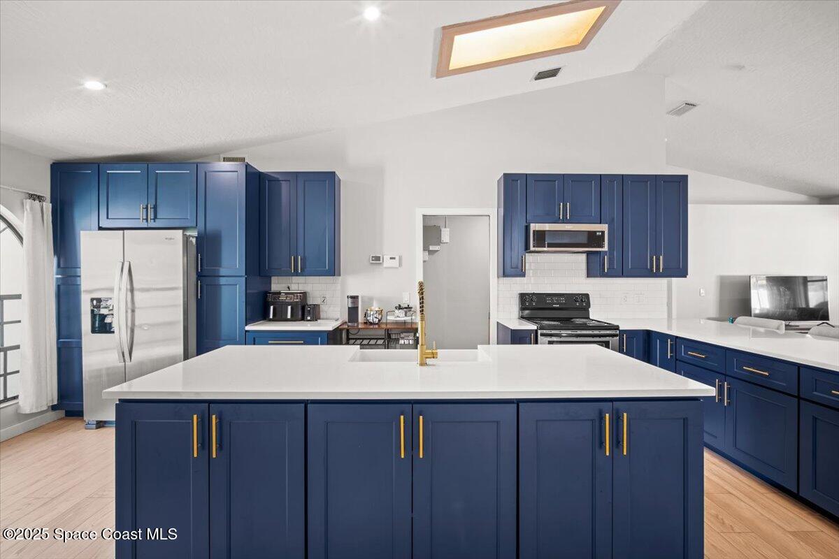 1709 Palm Ridge Road Melbourne, FL 32935 - Photo 13 of 43 a kitchen with a sink a stove a refrigerator and cabinets