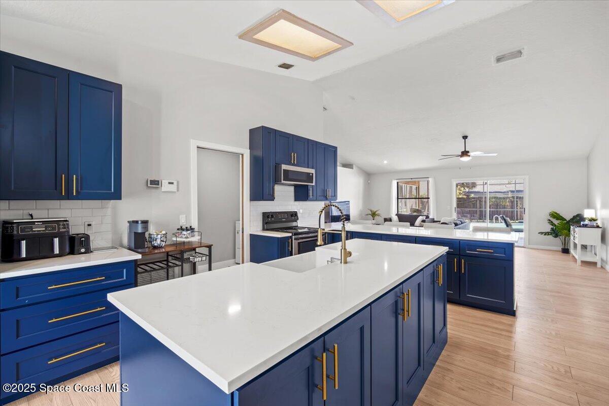 1709 Palm Ridge Road Melbourne, FL 32935 - Photo 15 of 43 a kitchen with wooden cabinets a sink dishwasher and a stove with wooden floor