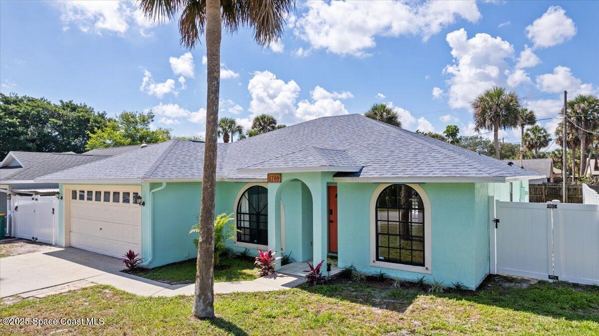 1709 Palm Ridge Road Melbourne, FL 32935 - Photo 2 of 43 a front view of a house with garden