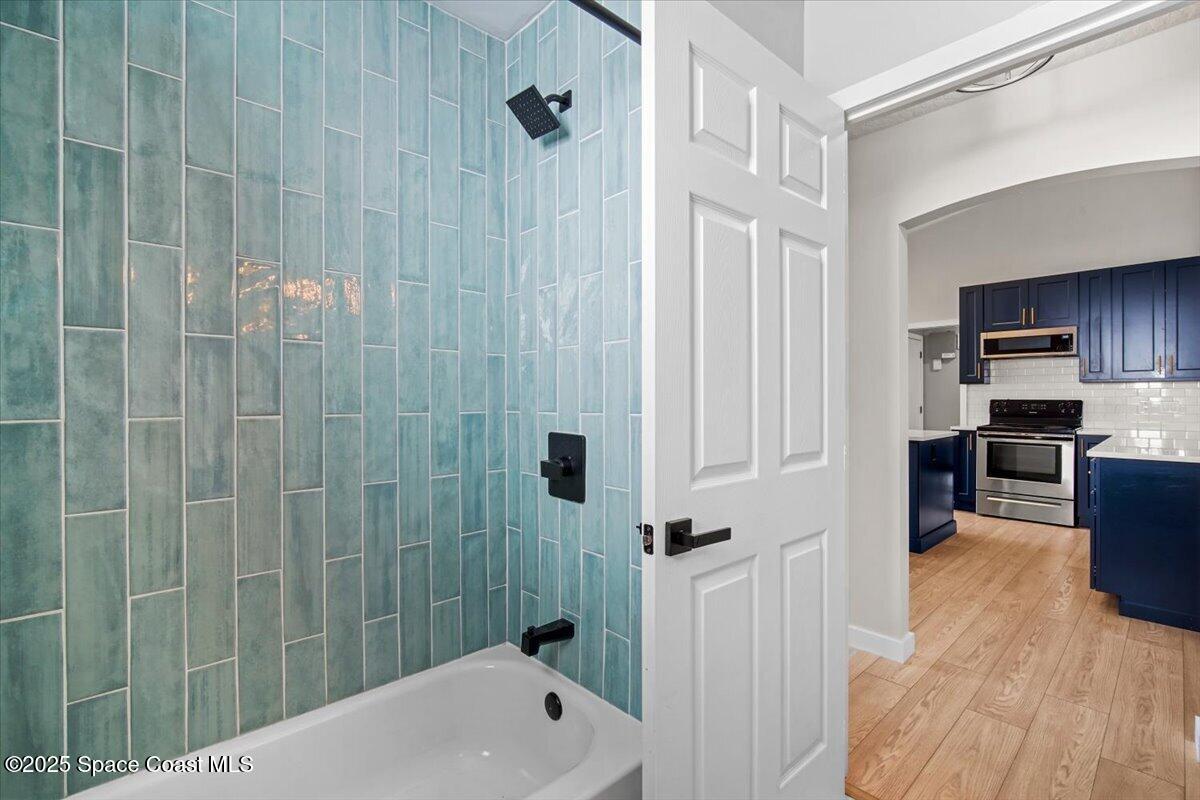 1709 Palm Ridge Road Melbourne, FL 32935 - Photo 22 of 43 a bathroom with a bathtub a sink a window and a shower