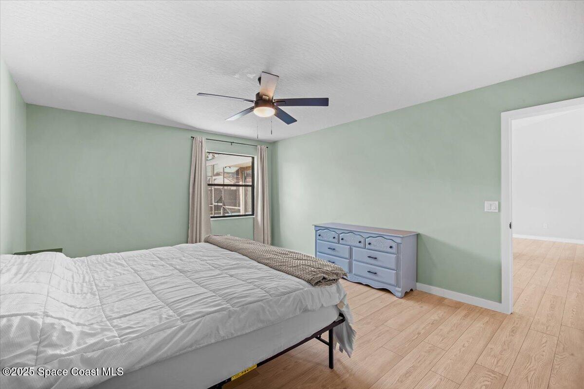 1709 Palm Ridge Road Melbourne, FL 32935 - Photo 26 of 43 a bedroom with a bed dresser and a window