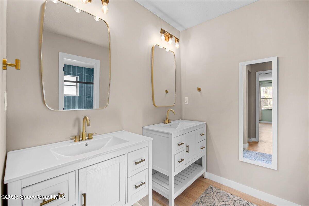 1709 Palm Ridge Road Melbourne, FL 32935 - Photo 30 of 43 a bathroom with a double vanity sink mirror and