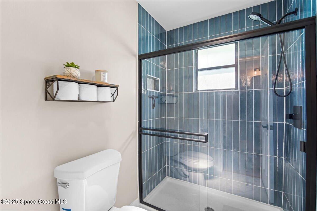 1709 Palm Ridge Road Melbourne, FL 32935 - Photo 31 of 43 a bathroom with a toilet and a shower