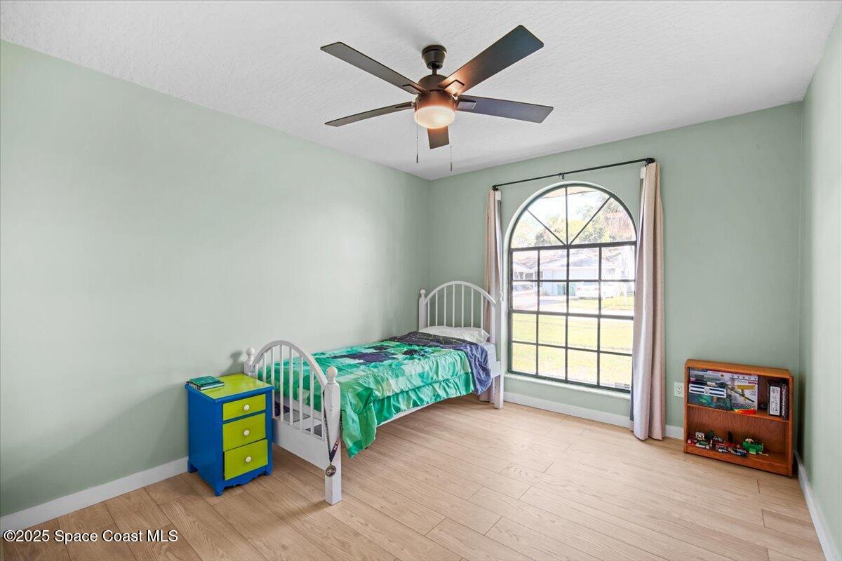1709 Palm Ridge Road Melbourne, FL 32935 - Photo 32 of 43 an empty room with windows and ceiling fan