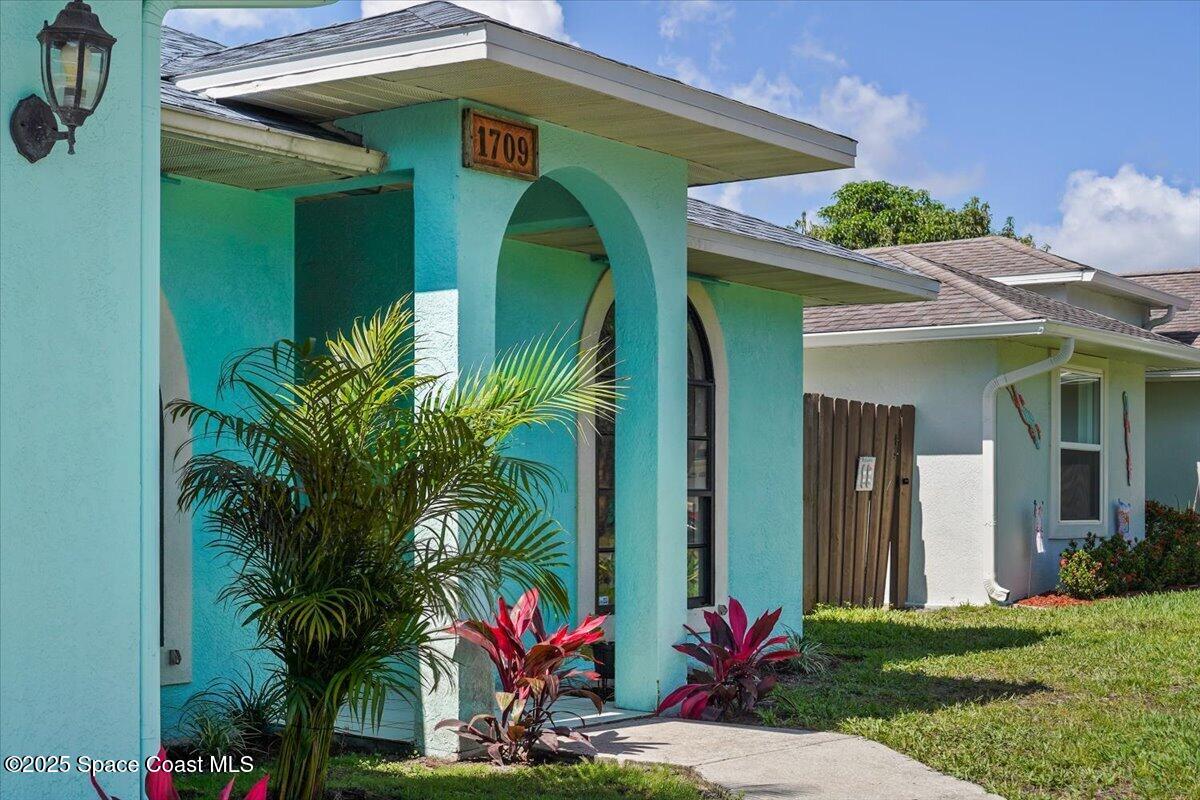 1709 Palm Ridge Road Melbourne, FL 32935 - Photo 4 of 43 a front view of a house with a yard