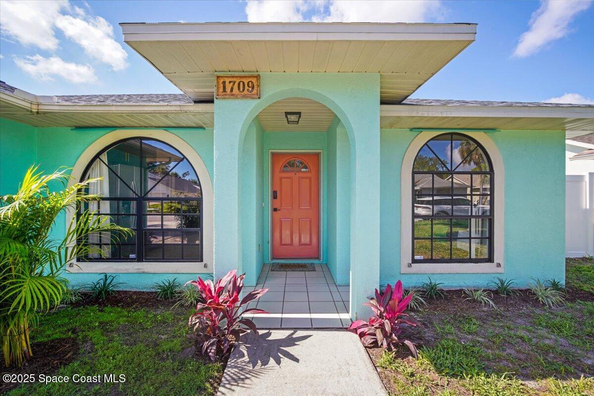 1709 Palm Ridge Road Melbourne, FL 32935 - Photo 5 of 43 a front view of a house with garden