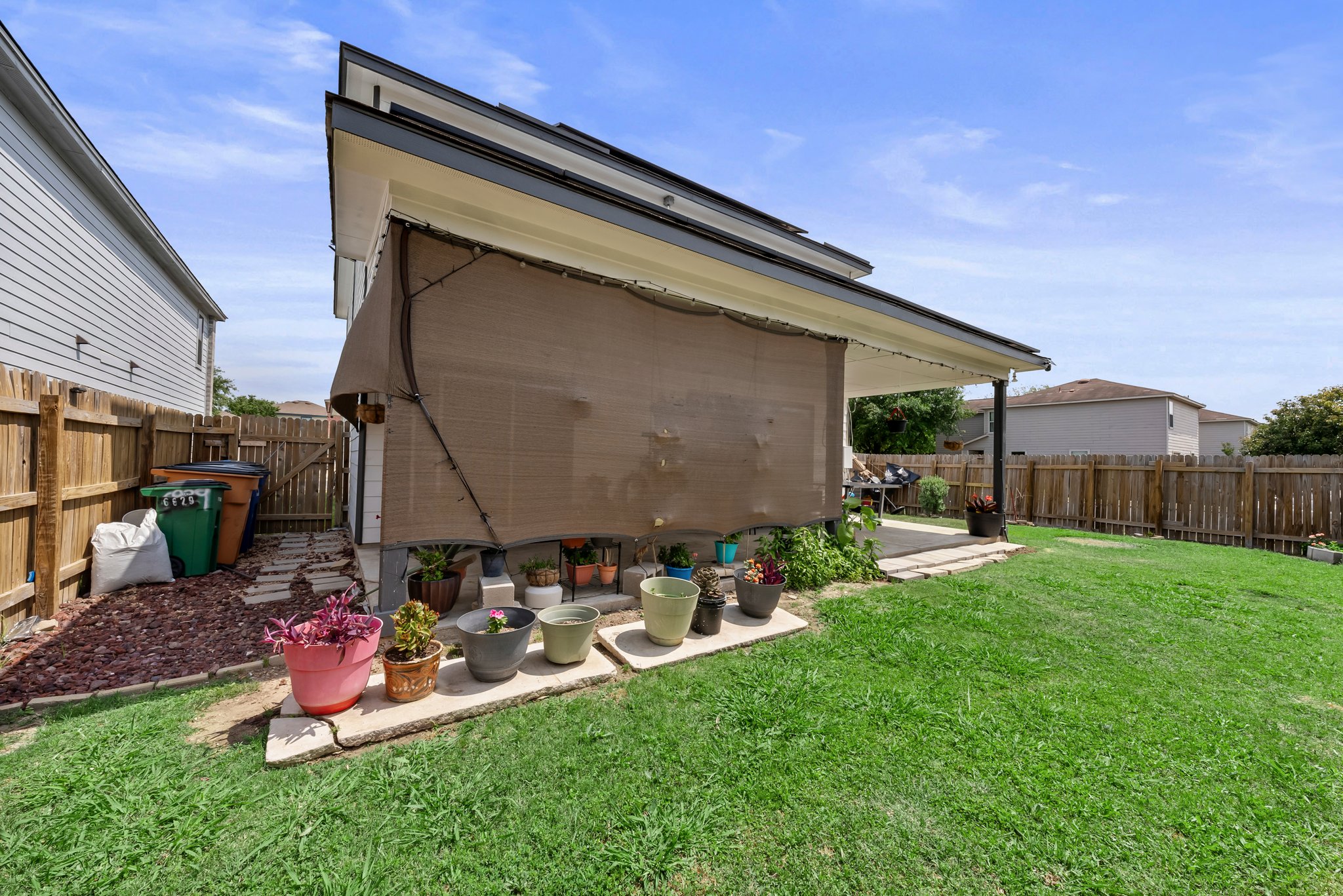 6829 Walkup Lane Austin, TX 78747 - Photo 18 of 18 A well-maintained lawn and shaded patio area await in this private backyard.