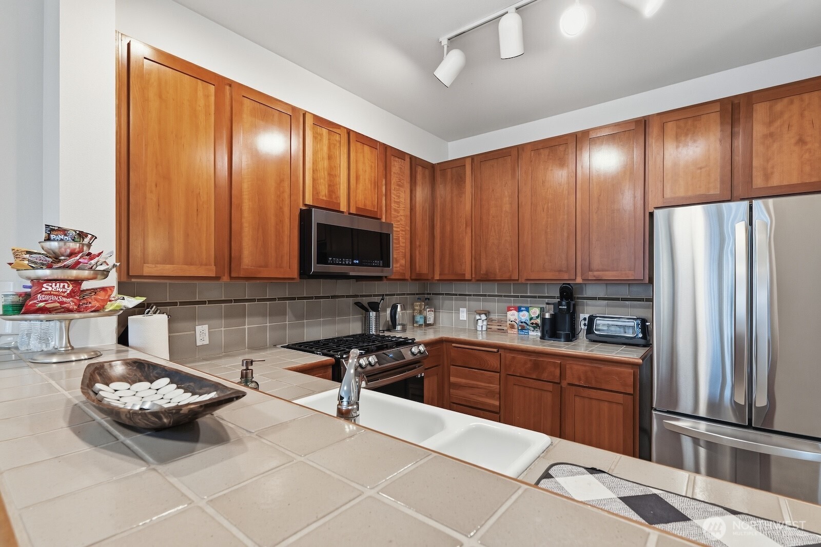 2000 Alaskan Way, Unit 553 Seattle, WA 98121 - Photo 16 of 33 a kitchen with stainless steel appliances a stove a sink and a refrigerator