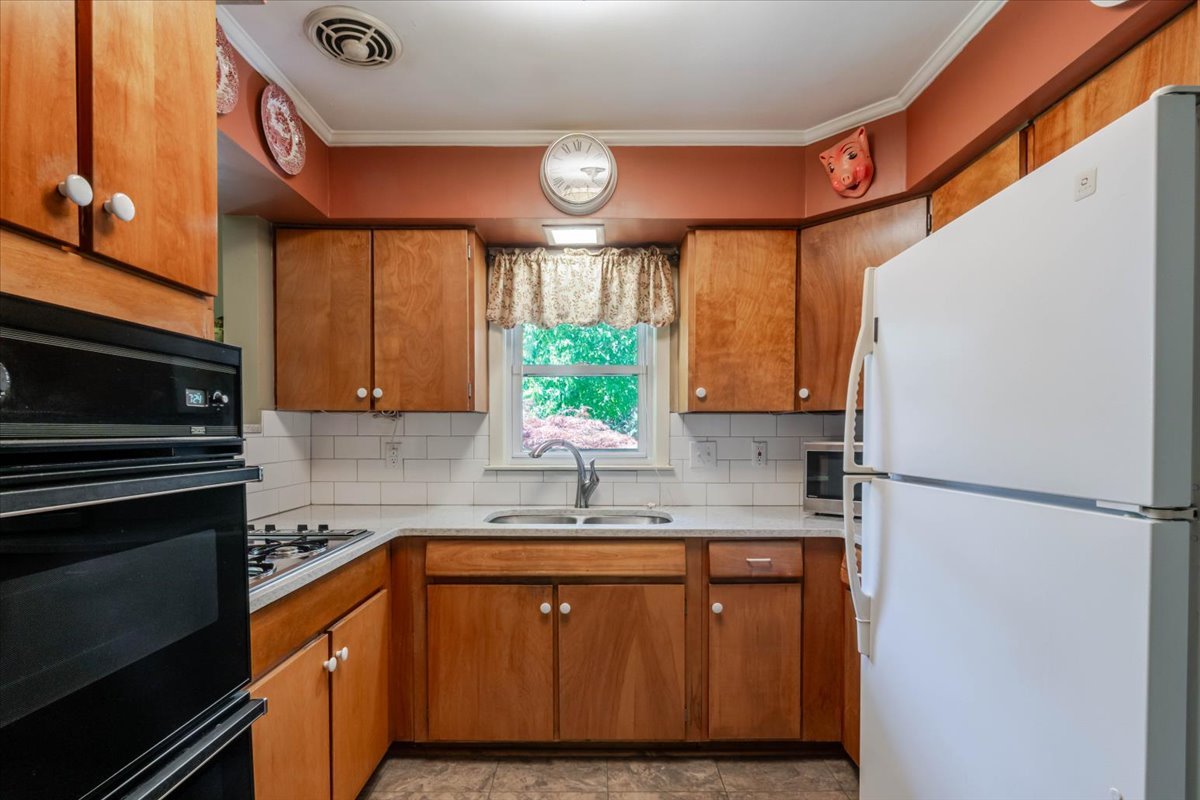 302 Radliff Road Bloomington, IL 61701 - Photo 12 of 35 a kitchen with a refrigerator a sink and cabinets