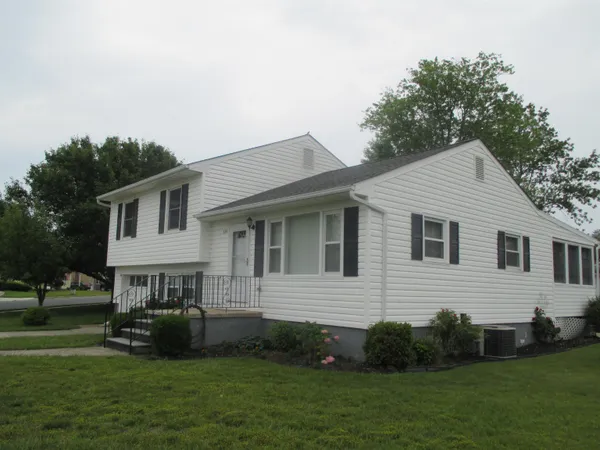 a view of big yard in front of house with trees