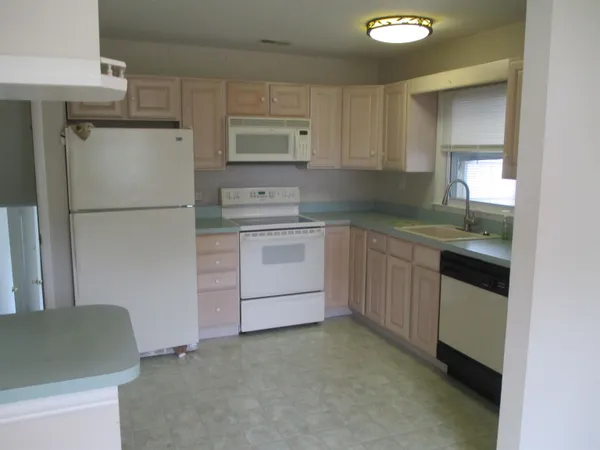 a kitchen with a refrigerator sink stove and cabinets
