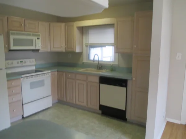 a kitchen with white cabinets and white appliances