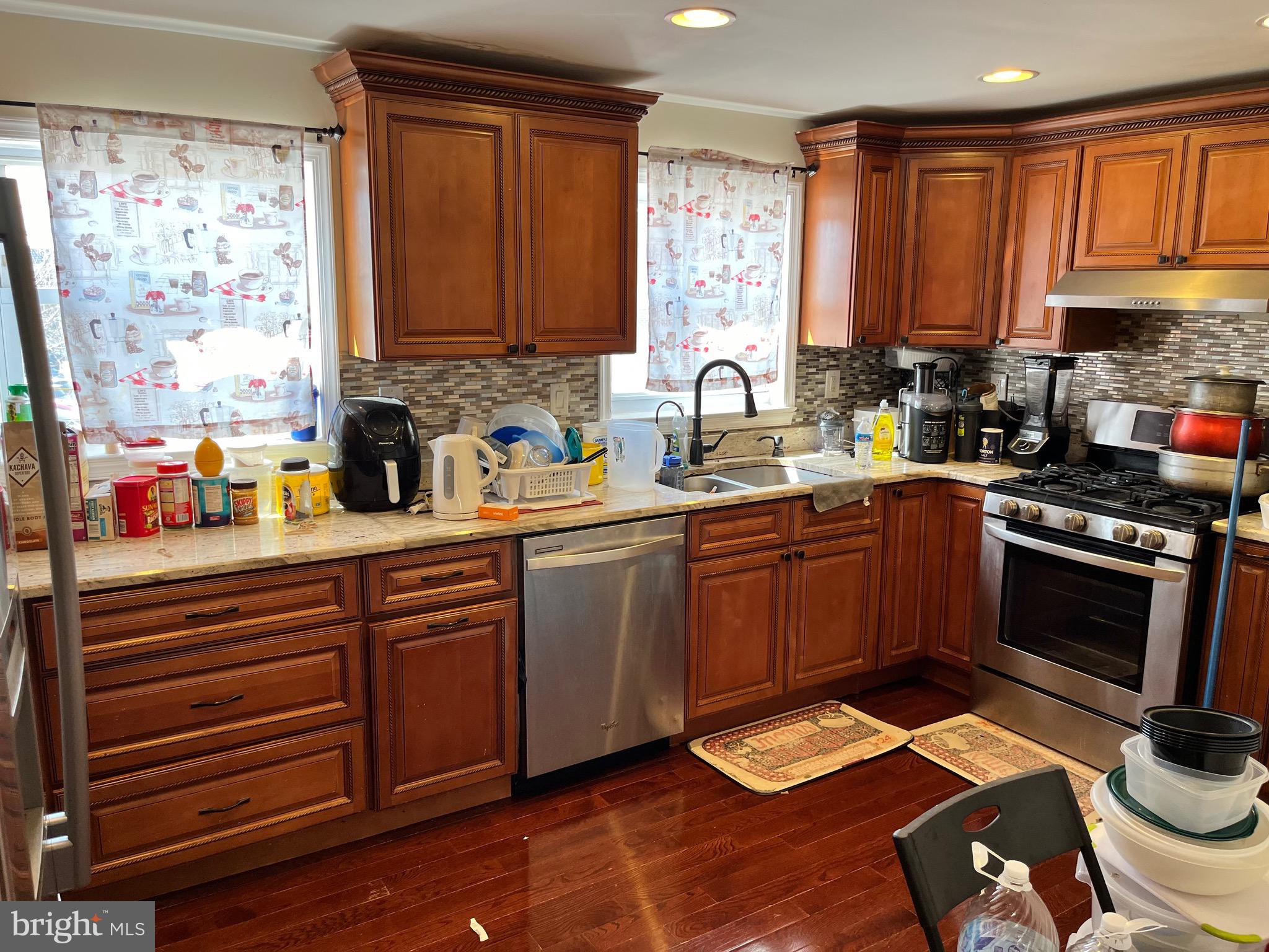 a kitchen with stainless steel appliances kitchen island granite countertop a sink dishwasher stove and cabinets