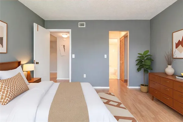 a bedroom with a bed and a potted plant