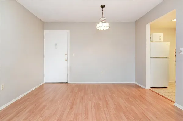 an empty room with wooden floor and mirror