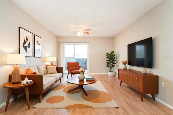 a living room with furniture a flat screen tv and a table