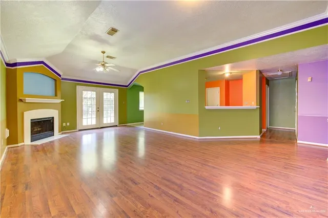 a view of empty room with wooden floor and fireplace