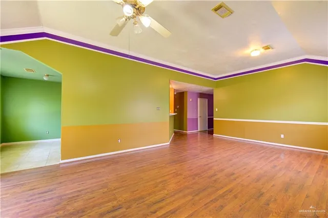 a view of an empty room with wooden floor