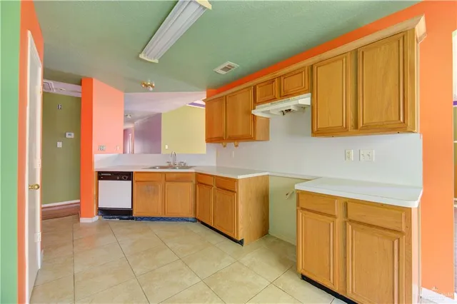 a kitchen with granite countertop a sink cabinets and stainless steel appliances