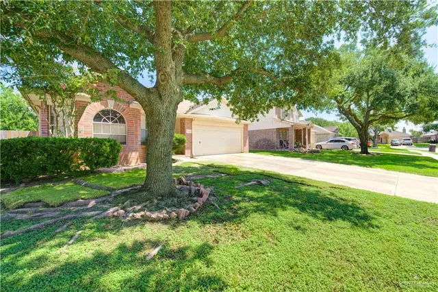 a front view of a house with yard and green space