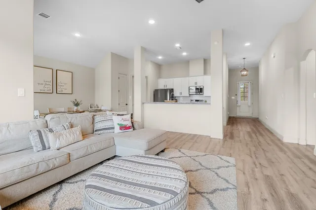 a living room with furniture and kitchen view