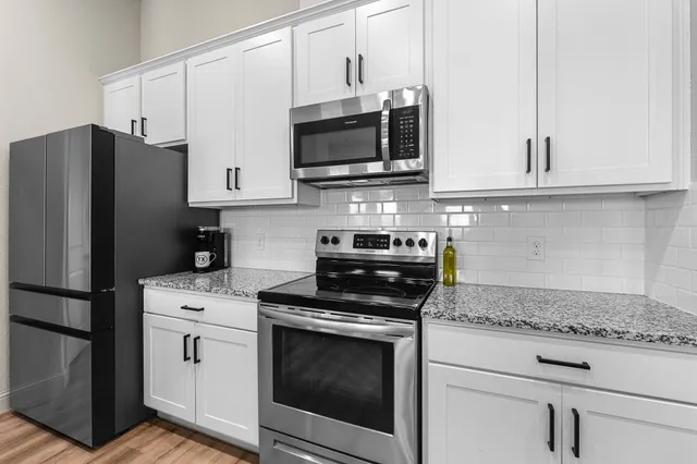 a kitchen with stainless steel appliances granite countertop a stove microwave and refrigerator