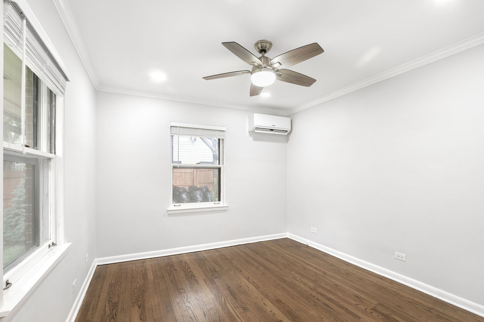 124 West Old Elm Road Lake Forest, IL 60045 - Photo 19 of 31 an empty room with wooden floor fan and windows