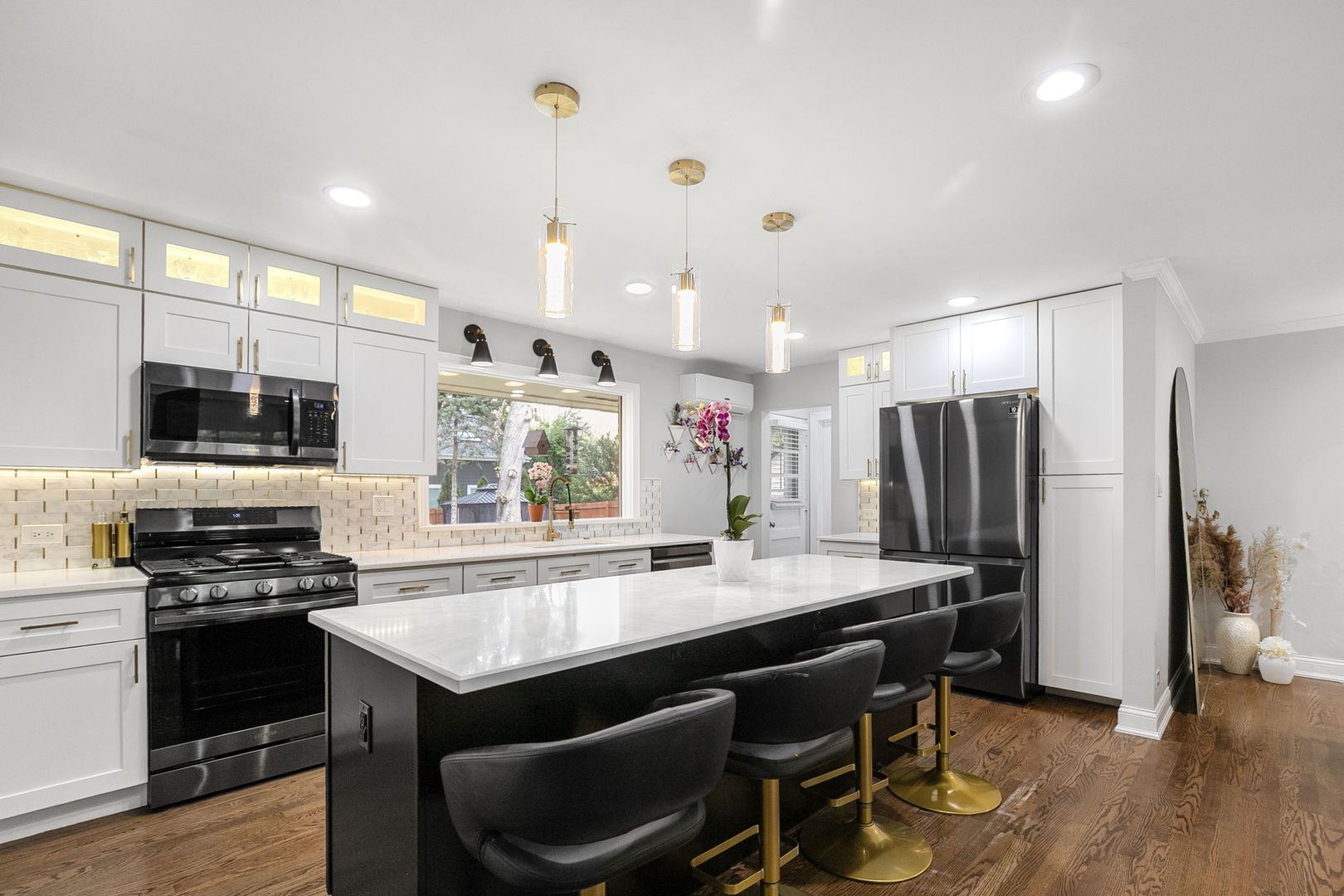 124 West Old Elm Road Lake Forest, IL 60045 - Photo 7 of 31 a kitchen with stainless steel appliances granite countertop a stove a refrigerator a sink dishwasher and a dining table with wooden floor