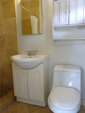 a white toilet sitting next to a bathroom sink