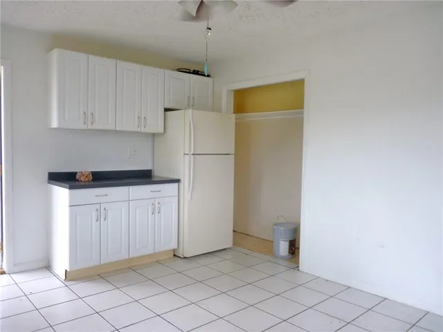 a kitchen with white cabinets and refrigerator