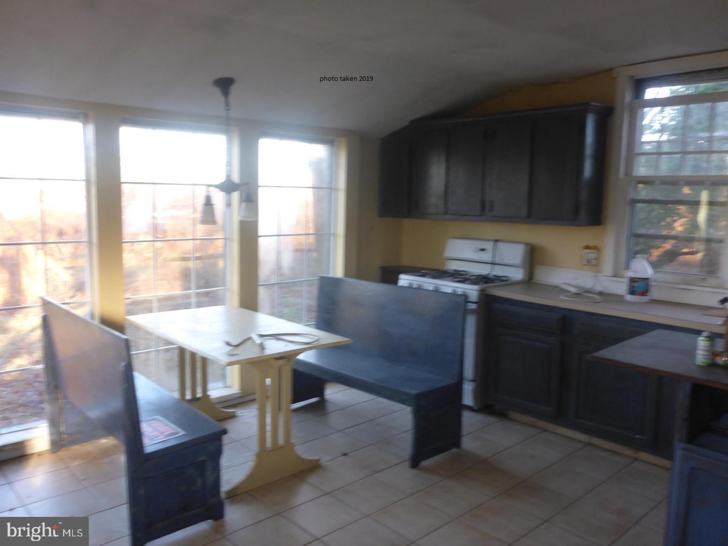 63 Money Island Road Salem, NJ 08079 - Photo 15 of 41 a kitchen with a table chairs sink and cabinets