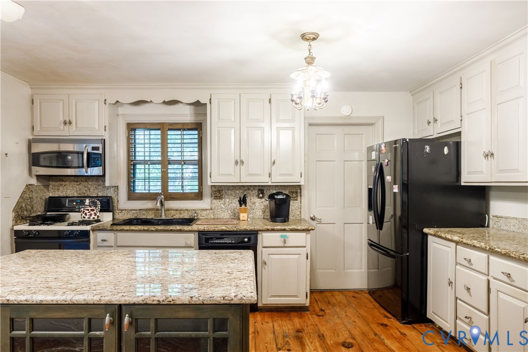 10760 Cherokee Road Midlothian, VA 23113 - Photo 13 of 43 a kitchen with kitchen island granite countertop a refrigerator stove top oven and sink
