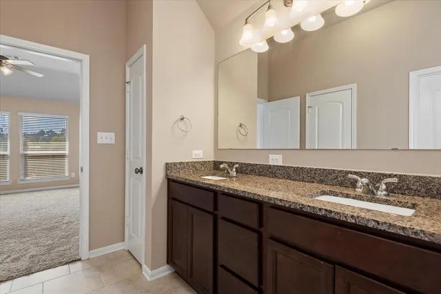a bathroom with a granite countertop sink a large mirror and a shower