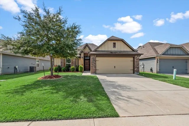 a front view of a house with a garden and yard