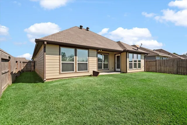 a view of a yard in front of a house with a large tree
