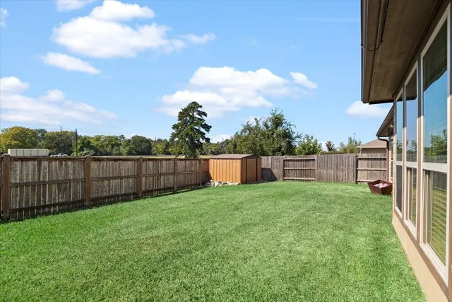 a view of a backyard with wooden fence