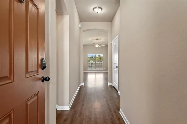 a view of a hallway with wooden floor and staircase