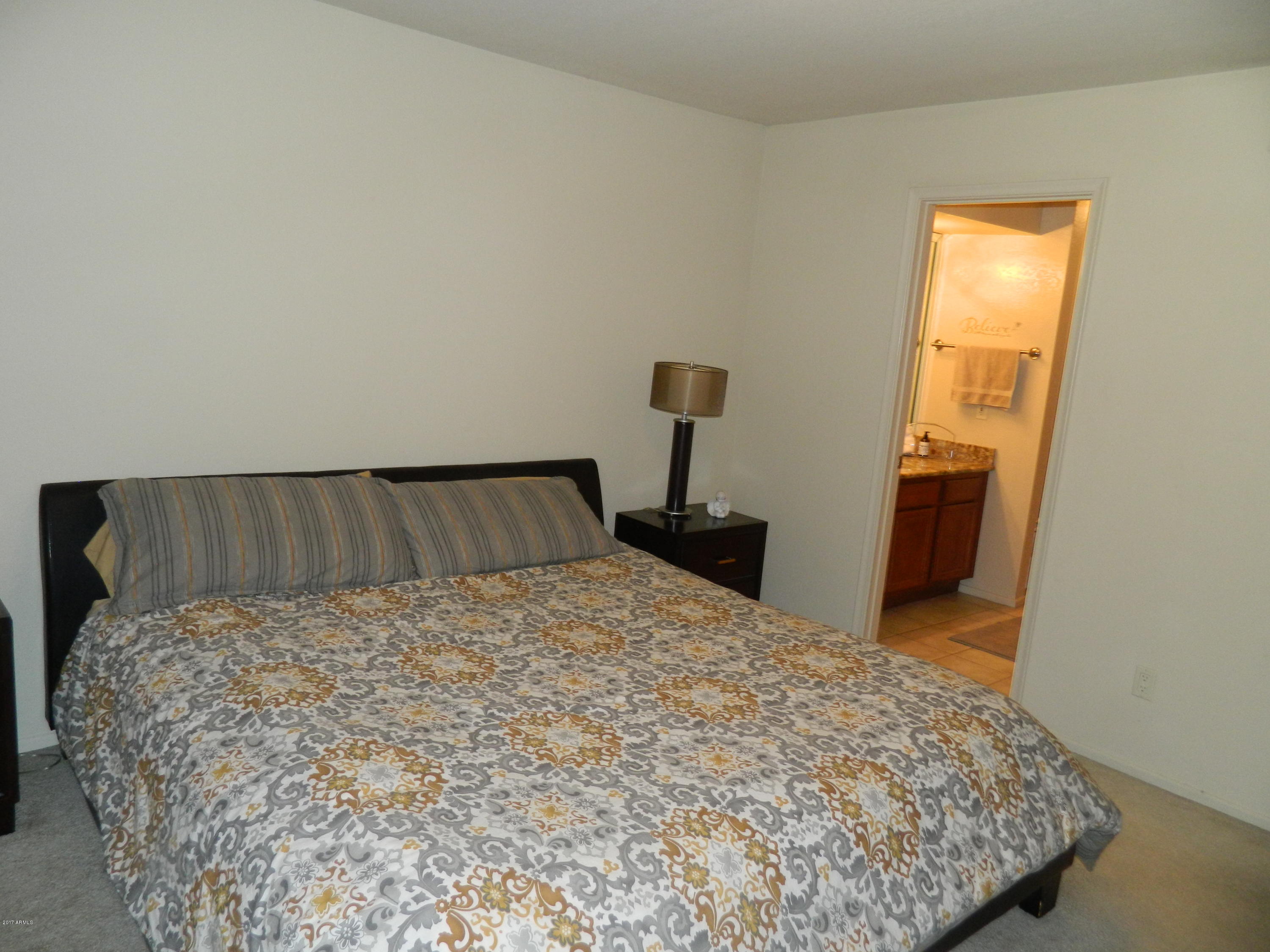 1402 East Guadalupe Road, Unit 245 Tempe, AZ 85283 - Photo 16 of 29 a bed sitting in a bedroom next to a window