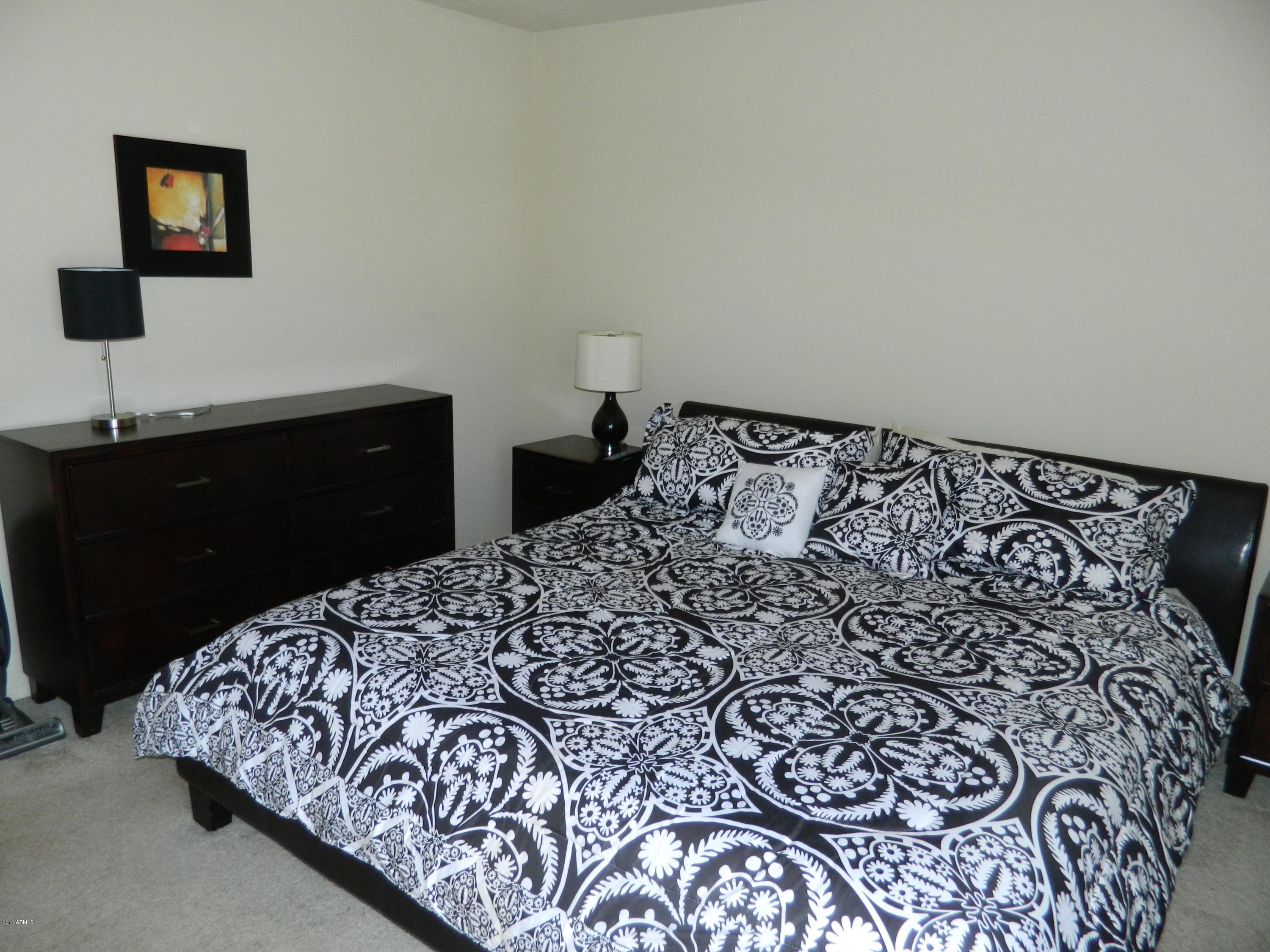 1402 East Guadalupe Road, Unit 245 Tempe, AZ 85283 - Photo 20 of 29 a bedroom with a bed and a lamp on dresser
