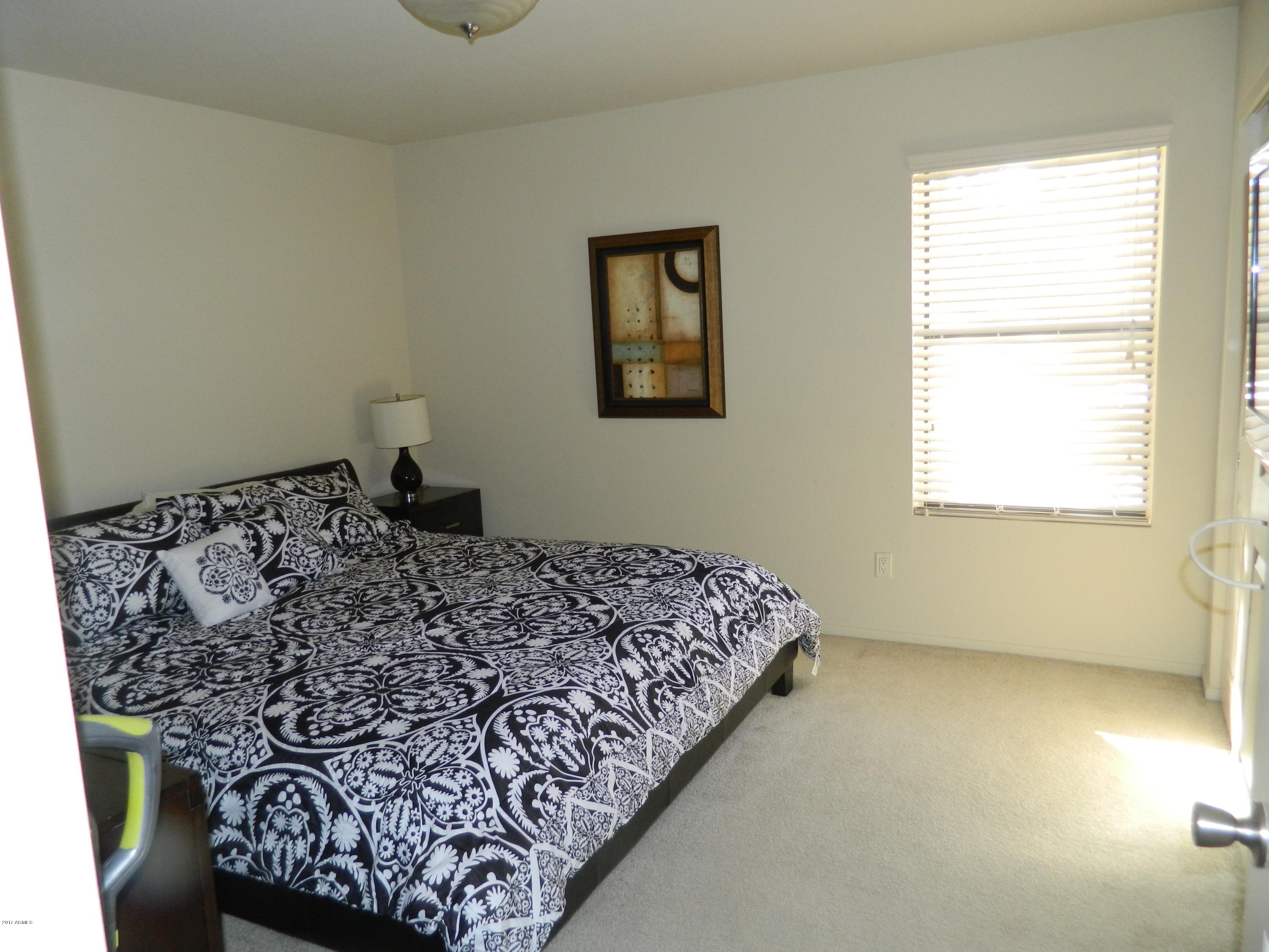 1402 East Guadalupe Road, Unit 245 Tempe, AZ 85283 - Photo 21 of 29 a bed sitting in a bedroom next to a window