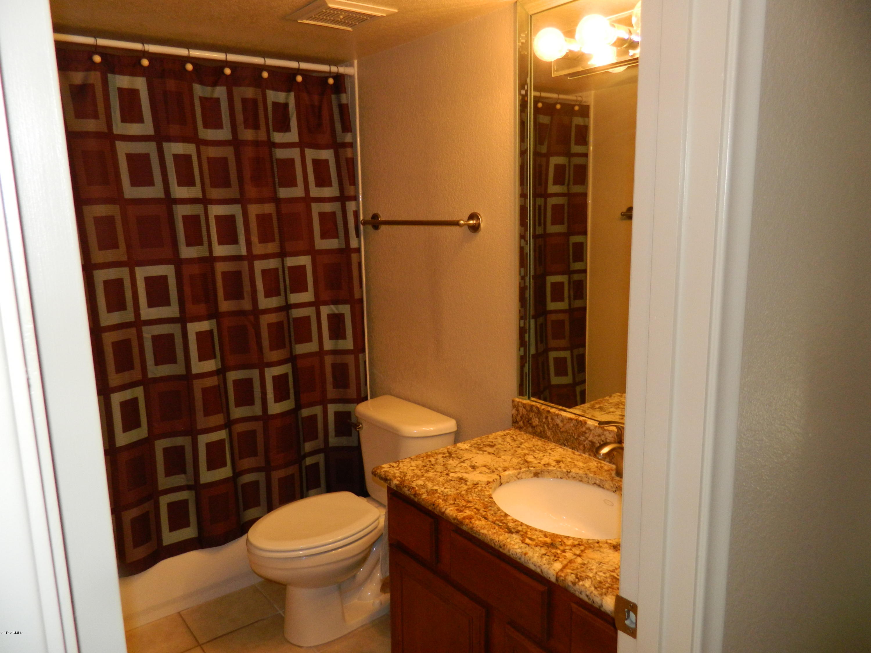 1402 East Guadalupe Road, Unit 245 Tempe, AZ 85283 - Photo 22 of 29 a bathroom with a granite countertop toilet and a shower