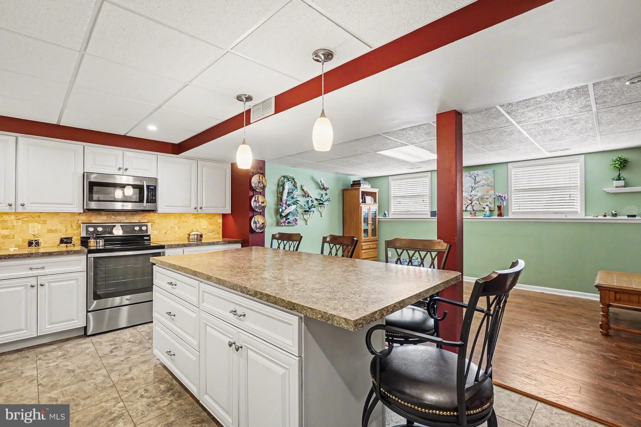8636 Winding Way Perry Hall, MD 21128 - Photo 22 of 40 a kitchen with stainless steel appliances kitchen island granite countertop a stove a sink a dining table and chairs