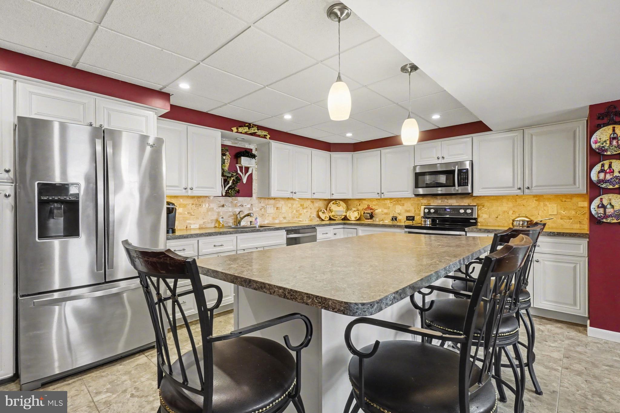 8636 Winding Way Perry Hall, MD 21128 - Photo 24 of 40 a kitchen with stainless steel appliances granite countertop a refrigerator a stove a sink a microwave with a dining table and chairs