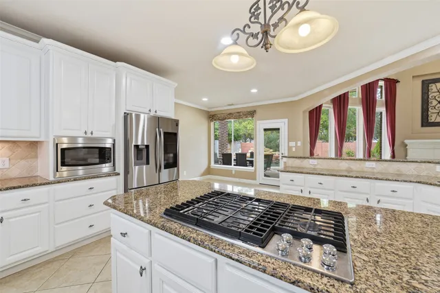 a living room with stainless steel appliances kitchen island granite countertop furniture and a fireplace