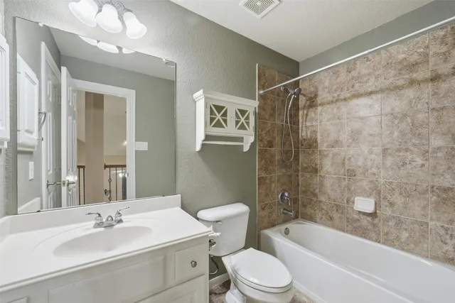 a bathroom with a sink a toilet a mirror a bathtub and shower