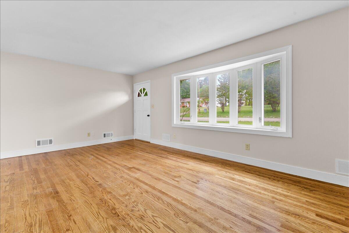 2646 Dickerson Mill Road Bedford, VA 24523 - Photo 5 of 46 a view of an empty room with wooden floor and a window