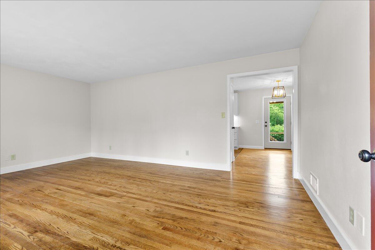 2646 Dickerson Mill Road Bedford, VA 24523 - Photo 6 of 46 a view of an empty room with wooden floor and a window