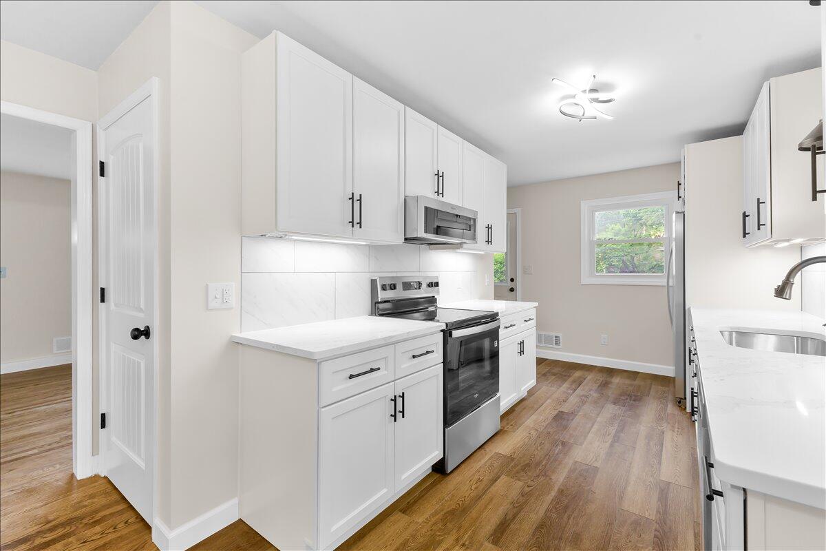 2646 Dickerson Mill Road Bedford, VA 24523 - Photo 9 of 46 a kitchen with white cabinets and white appliances