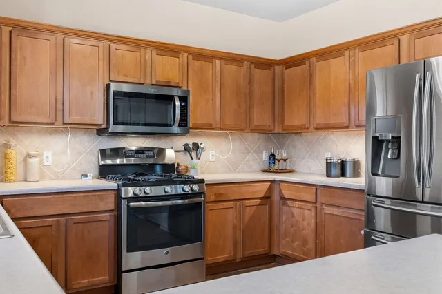 a kitchen with stainless steel appliances wooden cabinets and a stove top oven